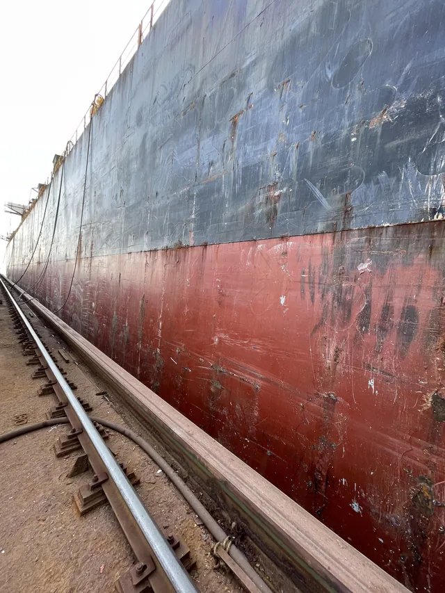 Side shell, boot-top and flat bottom along the dock wall rail. Shanghai, February 2025.