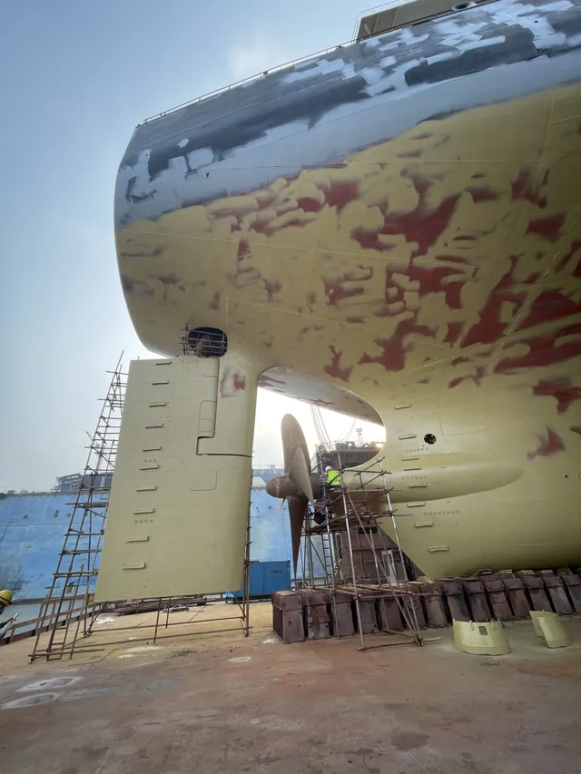 Stern, rudder and propeller in primer, with scaffolding. Shanghai, early 2026.